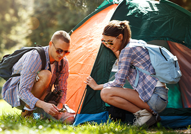 A man and a woman putting up a tent